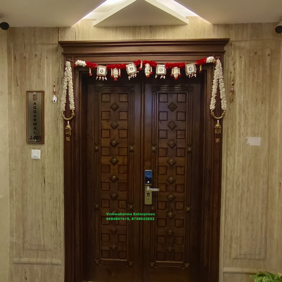 Hand-carved dark teak double main door with brass handles — Vishwakarma Enterprises install