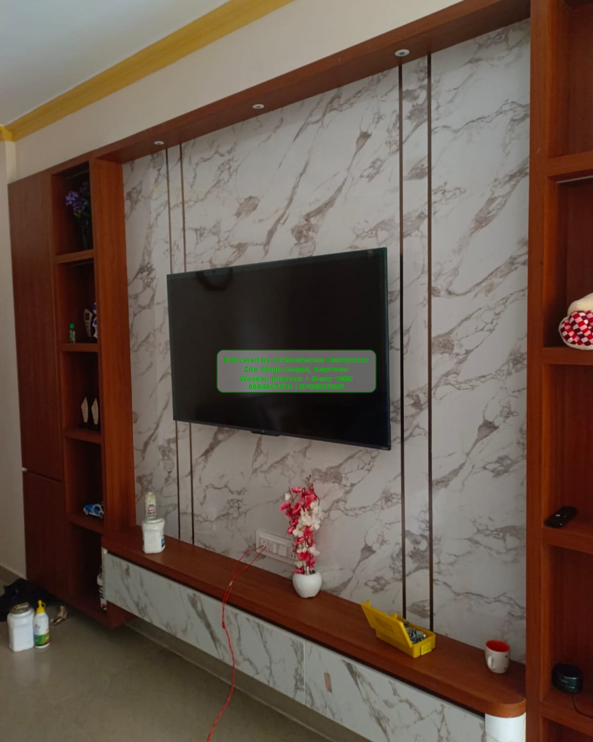 Marble TV panel framed by wood with cove lighting