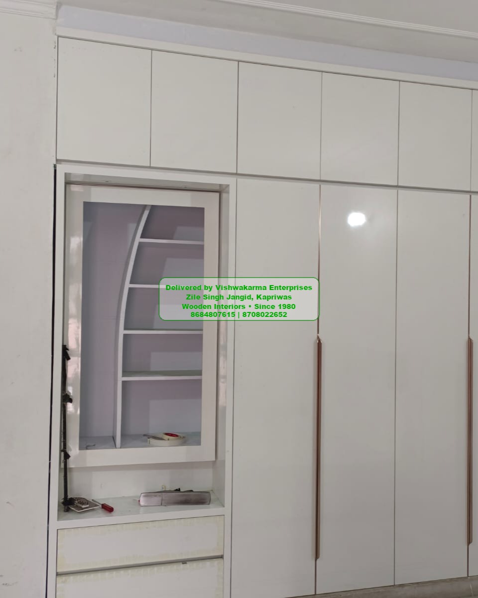 Tall white glossy wardrobe with adjacent open arched display niche and copper handles